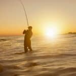 silhuet af en mand, der fisker på havet under solnedgang