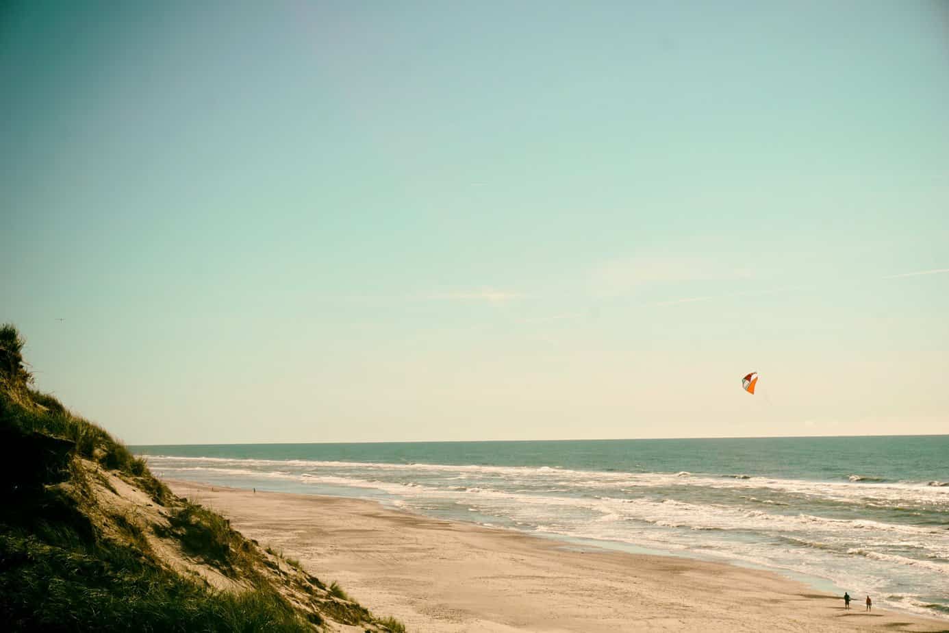 person flying kite on seashore