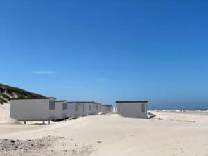 gray concrete houses on white sand during daytime